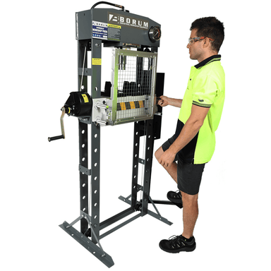 Person operating a Borum hydraulic press on a white background