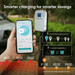 A hand holds a smartphone showing a charging app screen in front of an outdoor EV charger, with promotional text and feature callouts about smarter charging and scheduling.