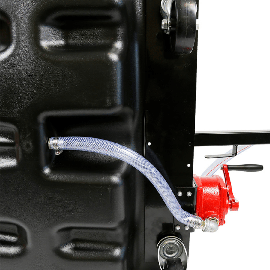 Close-up of a mechanical pump with a red handle and metal hose attached to a black metal surface.