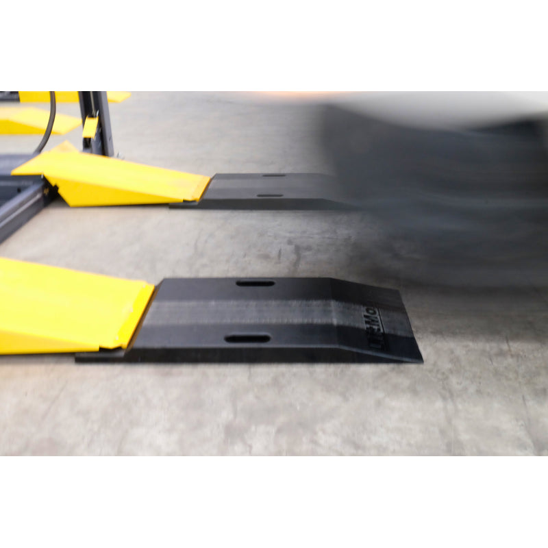 Car driving onto a lift over Liftmotive extension ramps
