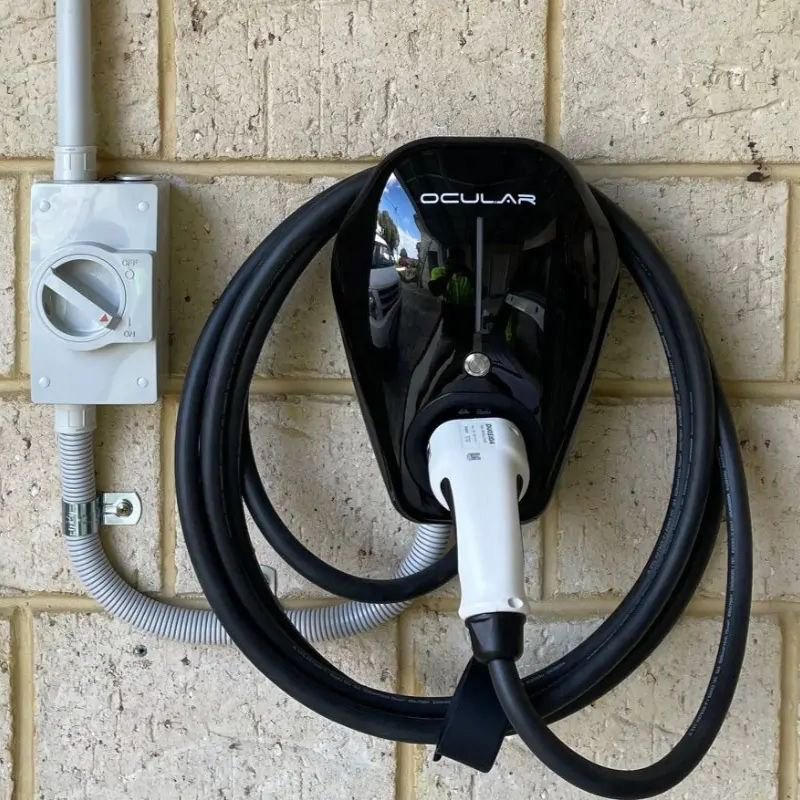 Black Ocular IQ EV charger with Type 2 cable mounted on a brick wall